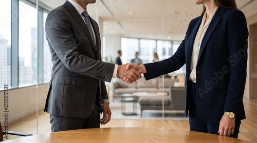 Close up of business partners shaking hands in a modern office, sealing a deal or agreement, representing partnership, trust, cooperation, negotiation, and successful professional