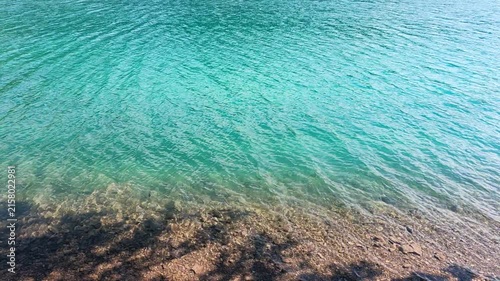 A stunning alpine lake surrounded by dramatic mountain peaks and dense evergreen forests. The crystal-blue Moraine Lake water reflects the peaceful wilderness landscape