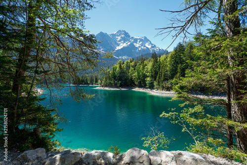 Travel landscape of Zugspitze Alps in Bavaria, Germany, scenic summer nature panorama with forest, Eibsee lake, snow mountains peak. Alpine landscape
