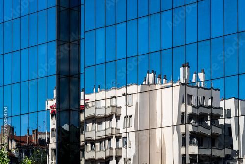 Reflections on a contemporary building facade showing glass windows and urban city architecture exterior