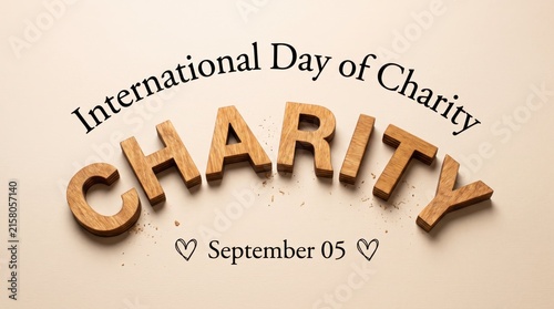 International day of charity concept featuring wooden letters arranged in an arch formation on a clean light beige textured background