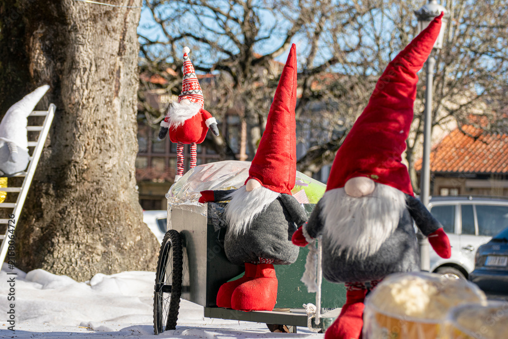 Obraz premium Nordic nisse figurines on cart in winter square The Concept of Christmas decoration