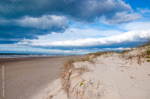 Panoramic view of the dunes with a blue sky and clouds in the background.