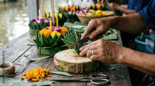 Hands crafting traditional Thai krathong for Loy Krathong festival.
