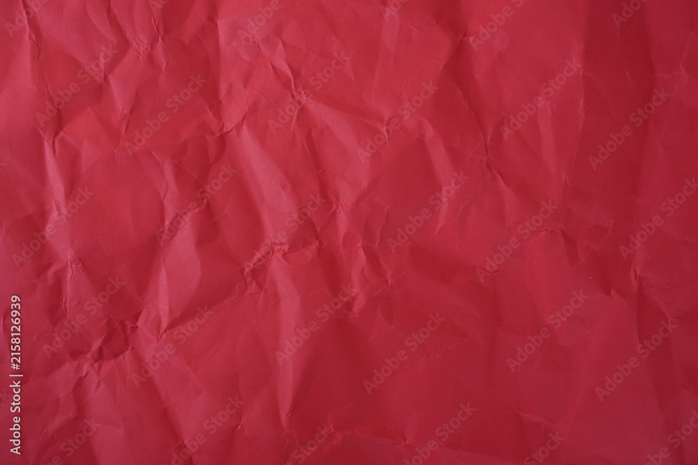 Fototapeta premium Crumpled red paper texture background with deep wrinkles, folds, and subtle shadows