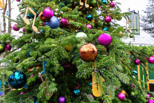 Canvas Print Festive glass ornaments decorating snowy Christmas tree.