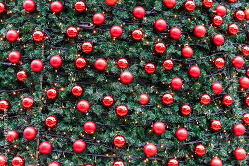 Festive glass ornaments decorating snowy Christmas tree.