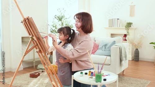 Girl and Mom Are Painting Together at Home During Afternoon Playtime