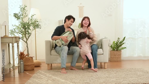 Parent Helps Child Prepare for School While Another Parent Shares a Moment in the Living Room