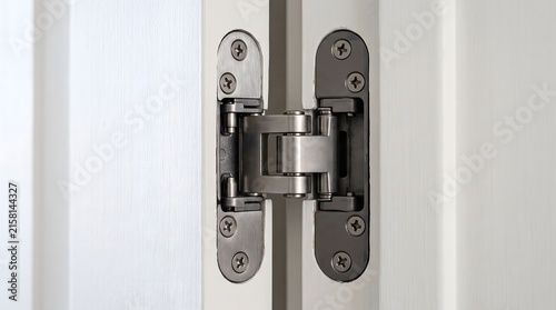 Modern concealed door hinge hardware made of brushed metallic steel material.