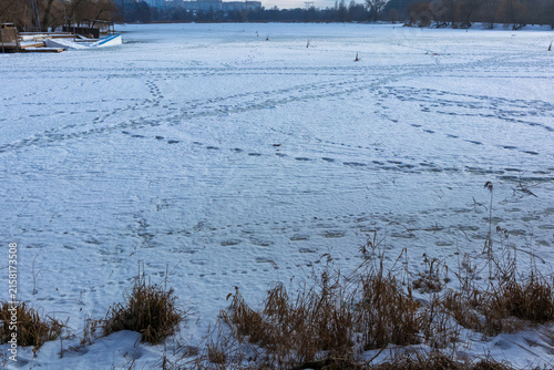 Footprints on frozen snow covered lake in winter countryside