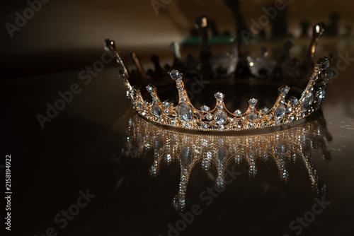 Canvas Print Golden Royal Crown with Crystal Details and Reflection on Brown Background