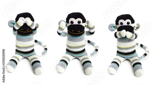 Three toy monkeys isolated on white background with hands on eyes, ears and mouth