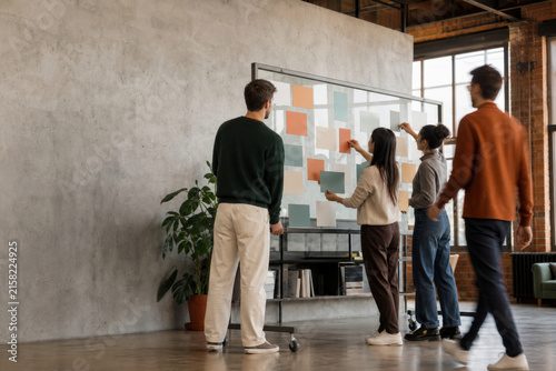 Moving Team Brainstorming on Glass Board in Modern Interior with Copy Space