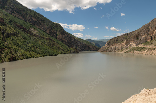 Majestic rocky cliffs tower above winding river and green valley