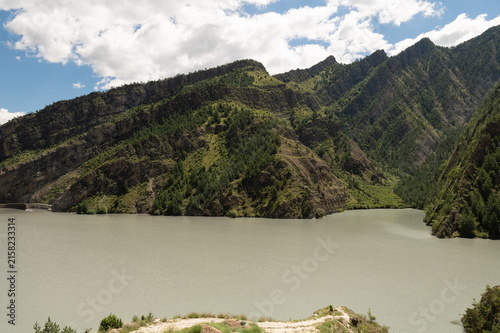 Majestic rocky cliffs tower above winding river and green valley