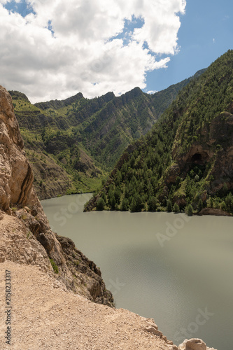 Majestic rocky cliffs tower above winding river and green valley