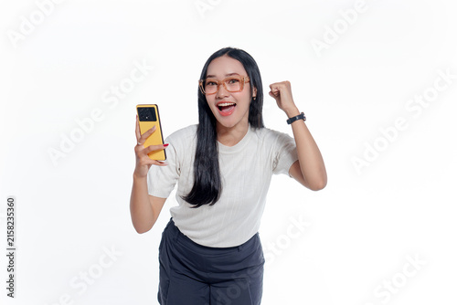 Excited Young Asian Woman Celebrating While Holding a Smartphone