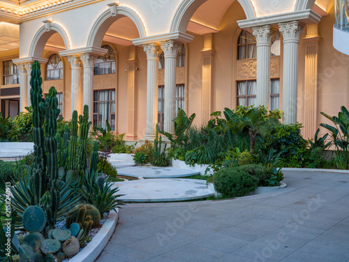 Foto European classical building facade with tropical cactus garden at evening sunset