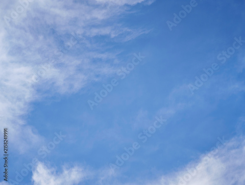 Clean bright blue sky background with light wispy clouds for presentation design