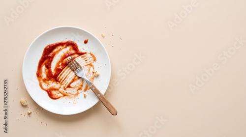 Empty white plate with red sauce smear and wooden spoon on light background