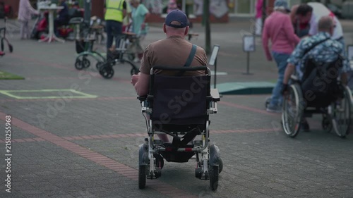 Group of wheelchair users gathers outdoors and shares a relaxed moment together, illustrating peer support, friendship, social connection, disability inclusion, community belonging.