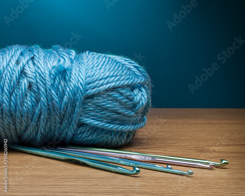 Obraz na płótnie Thick blue yarn and crochet hooks on a blue background
