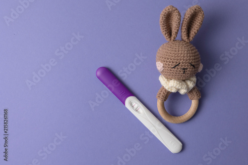 Foto Positive Pregnancy Test with White Orchid on Color Background