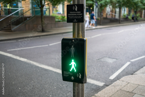 Canvas Print Green pedestrian crossing light signal activated at urban street intersection