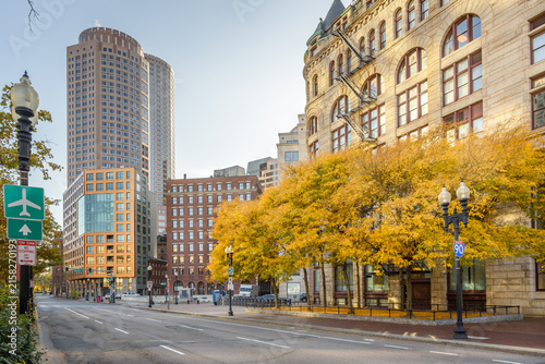 Empty wide street lined with both modern and traditional office buildings in a financial district on a sunny autumn day