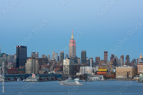 Fotografie New York City Manhattan Skyline with Empire State Building lit up in red and Sky