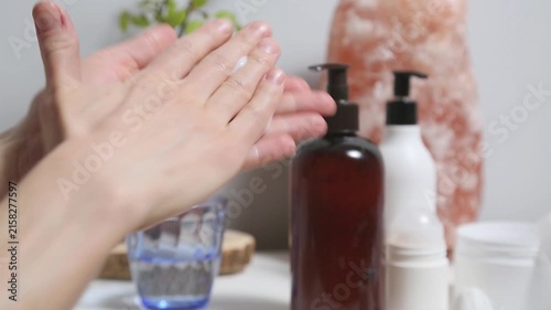 Woman performing a relaxing hand and wrist self massaging as part of a wellness and selfcare routine at home. Female applying cream from tube to care moisturizing her palms skin