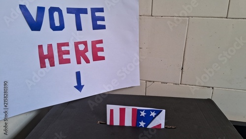 Photography Paper ballot featuring american flag design entering black plastic voting box
