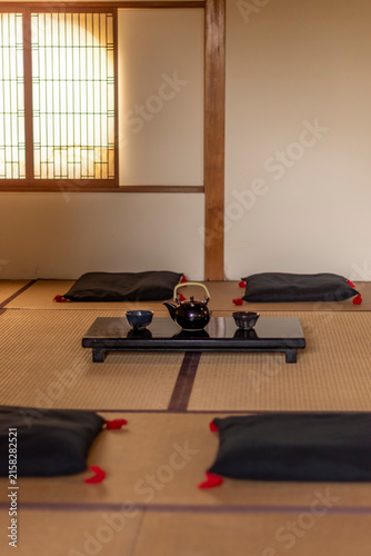 Traditional Japanese tea room with teapot tea cups and cushions on tatami mats