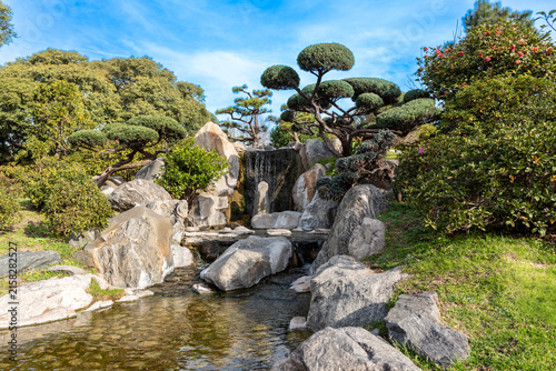 Waterfall surrounded by ornamental rocks and cloud trees in Japanese Garden of Buenos Aires