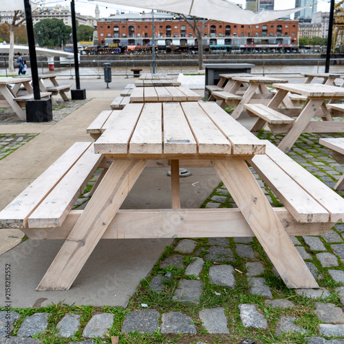 Empty wooden picnic tables along waterfront promenade in Puerto Madero district in Buenos Aires, Argentina
