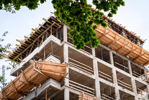 Low angle view of modern multistory building construction site with concrete structure and wooden formwork