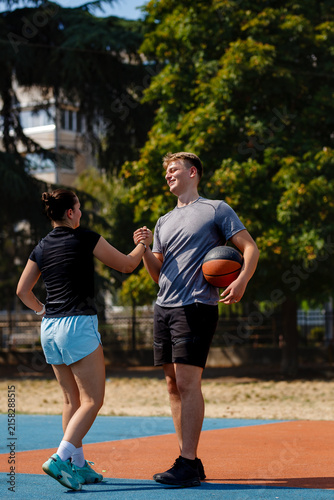 Foto Basketball players enjoying a friendly moment while practicing on an outdoor cou