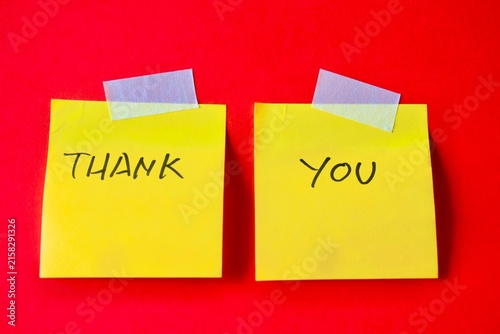 Obraz na płótnie Two yellow sticky notes taped to a red background with handwritten THANK YOU text