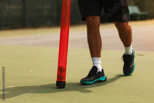 Obraz na plátně Person practices footwork drills on a tennis court with a red training stick and
