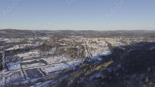 Keene, New Hampshire aerial video winter day. Drone footage flying over hill towards the downtown area of the largest city in the monadnock region of NH on a snowy morning.