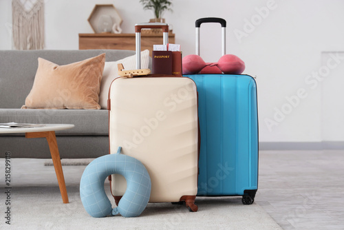 Interior of living room with stylish suitcases, travel pillows and passports