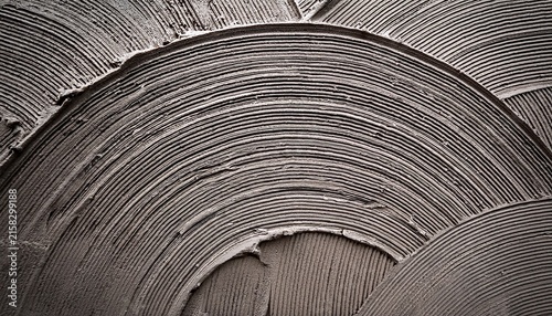 coarse mortar wall coating with distinct arched trowel impressions in a sharp focus macro shot for architectural and building material marketing