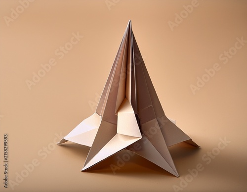 abstract origami folded paper sculpture on clean beige background with soft shadows