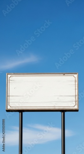 Blank white billboard against clear blue sky.