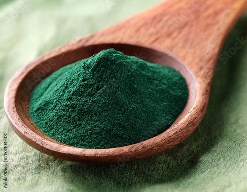 spirulina powder in wooden spoon