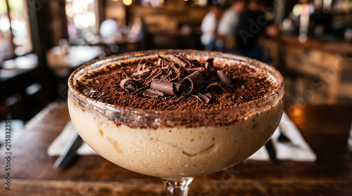 Delicious Tiramisu in a Cocktail Glass: A close-up of a delectable tiramisu dessert served in a martini glass, dusted with cocoa powder and chocolate shavings, ready to be savored.