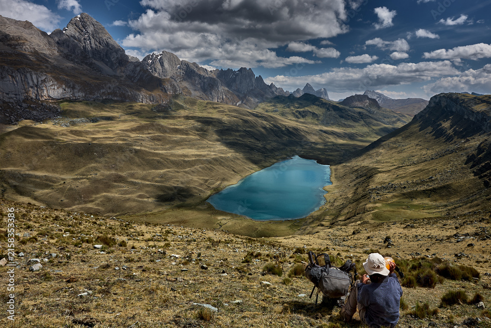 Fototapeta premium An awe-inspiring aerial view captures Mitucocha Lagoon nestled deep within the Cordillera Huayhuash, its brilliant turquoise waters standing out dramatically against the rugged green valley floor