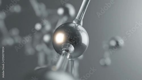 Silver metallic atom model on dark background.