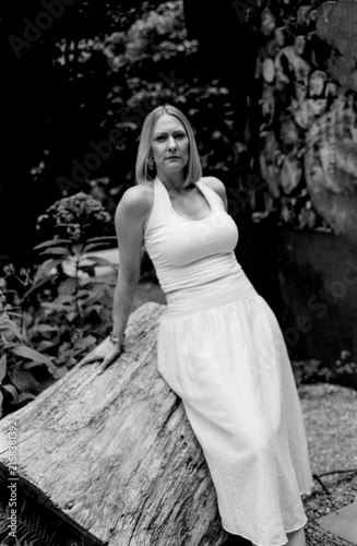 Photography Woman posing on a log in a vintage style garden